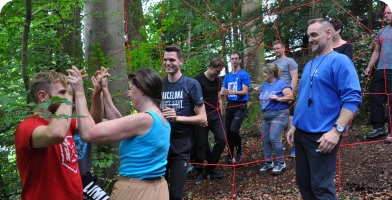 Bei der Teamworkübung Spinnennetz am lifeenergy 4 feiert die Gruppe ihre Erfolge.